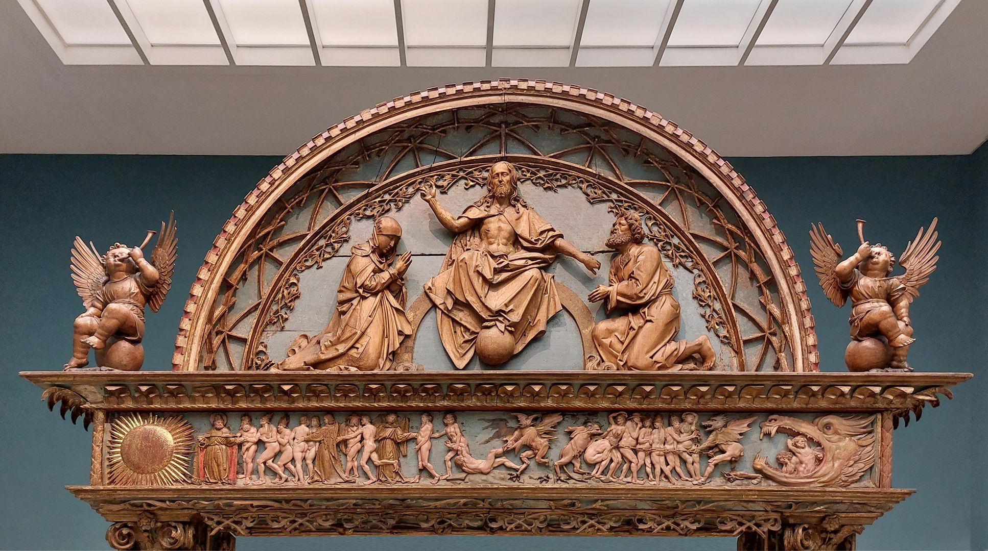 Altarretabel aus der Kapelle des Nürnberger Zwölfbrüderhauses Giebel, thronender Christus auf dem Regenbogen mit Assistenzfiguren. Die venezianische Giebelscheibe wurde spätgotisch mit Maßwerkfries verdeutscht.