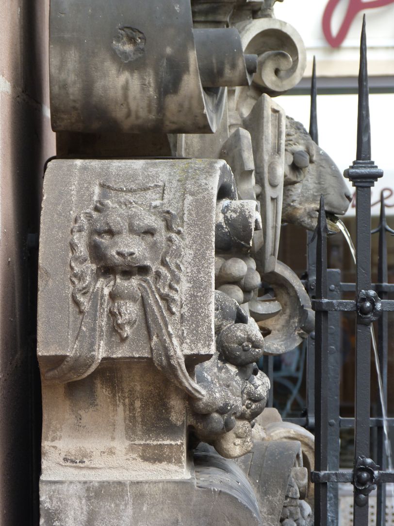 Fleischhauerbrunnen linkes Profil: das Löwenmaul hält die Girlande