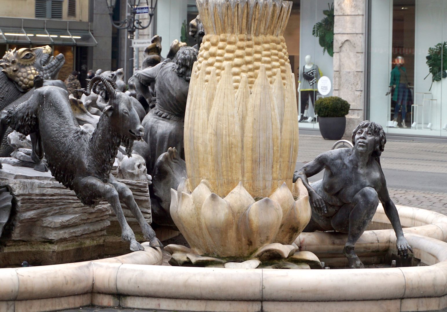 Ehekarussell / Hans-Sachs-Brunnen "Links und rechts vom Hans Sachs-Ständer der lebendige Bock und die Brunnennymphe als Symbole des Liebestriebes. Tod und Leben durchbrechen die kreisende Form des Ehekarussells." (J.W.)