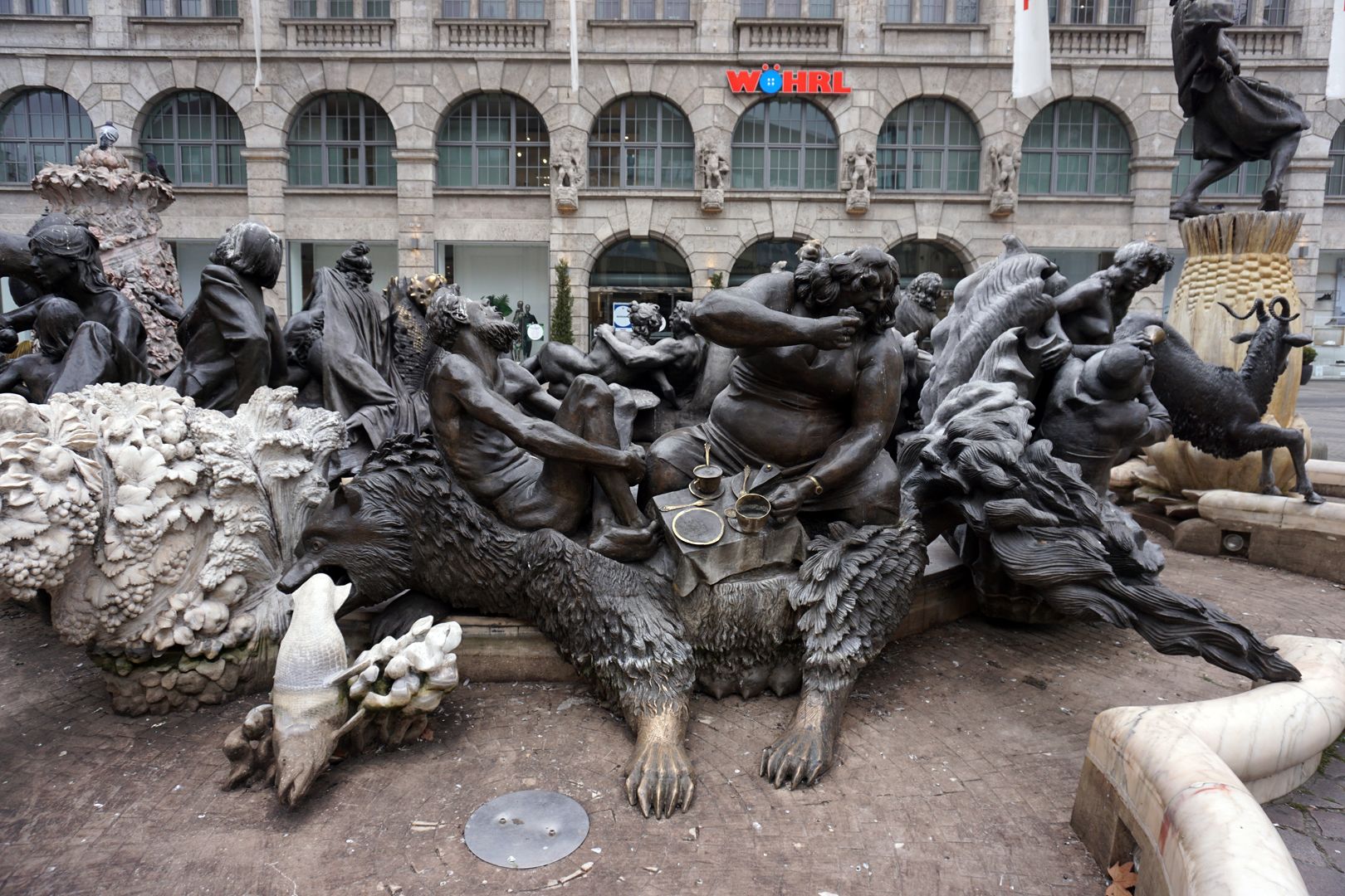 Ehekarussell / Hans-Sachs-Brunnen "Vielfraß" / Der Bär frisst einen Fisch, die Frau das Stück Kuchen des Mannes