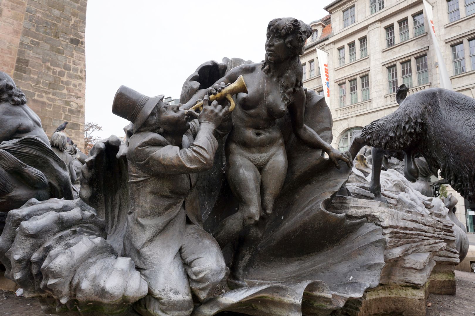 Ehekarussell / Hans-Sachs-Brunnen "Venusmuschel" / "Er besingt die nackte Schönheit mit seinem Instrument, die Muschel wird zur Jahrmarktbude" (J.W.)