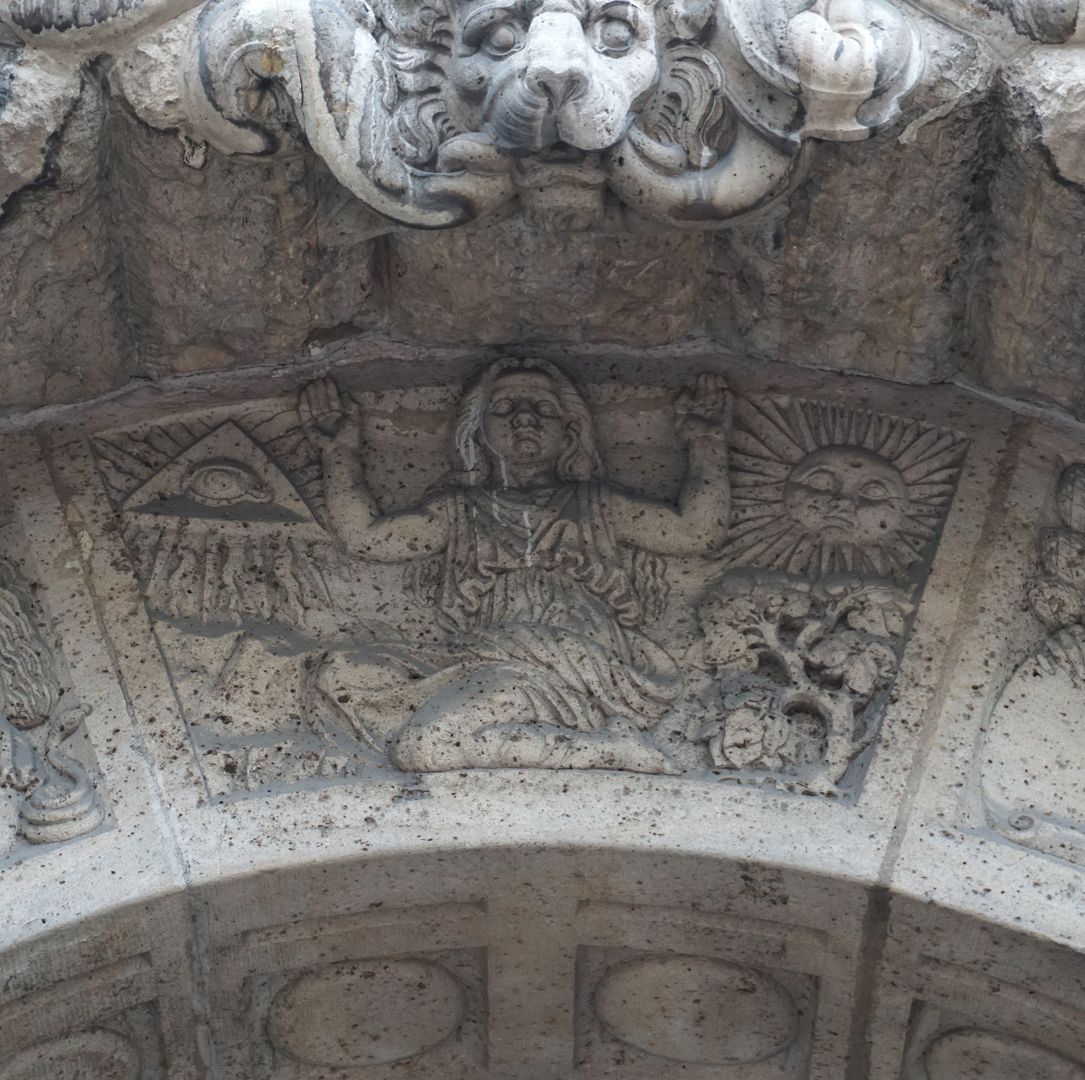 Fassadenschmuck am Melanchthon-Gymnasium "Religion", Eine kniende Frauengestalt, links das Auge Gottes, rechts die Sonne