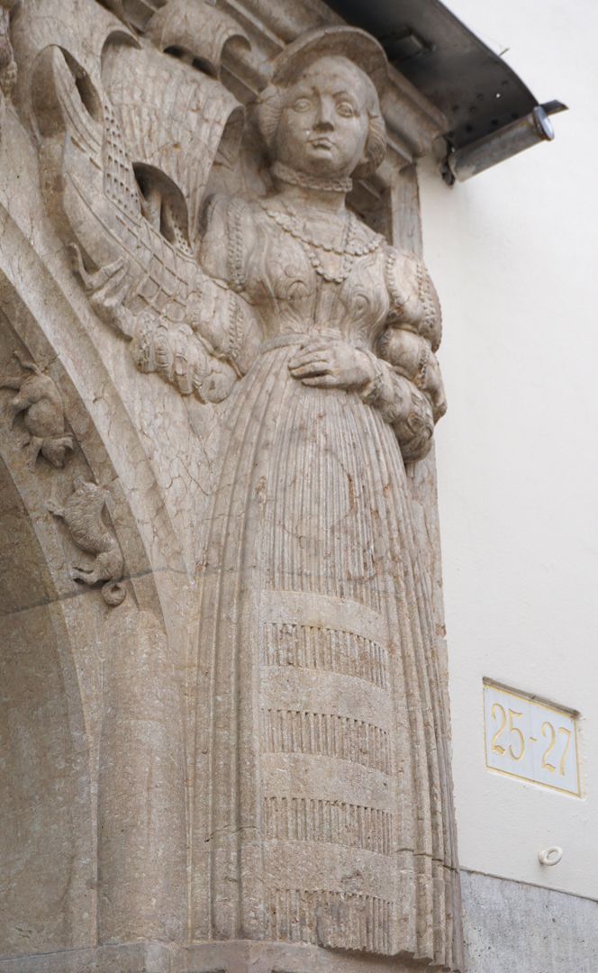 Portal rechte obere Ecke: eine Bürgerin in Renaissancekleidung hält ein Segelschiff, Schrägansicht