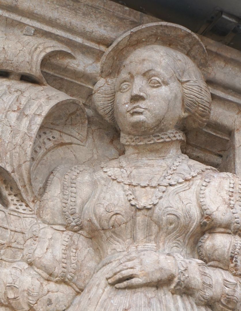 Portal rechte obere Ecke: eine Bürgerin in Renaissancekleidung hält ein Segelschiff, Detail