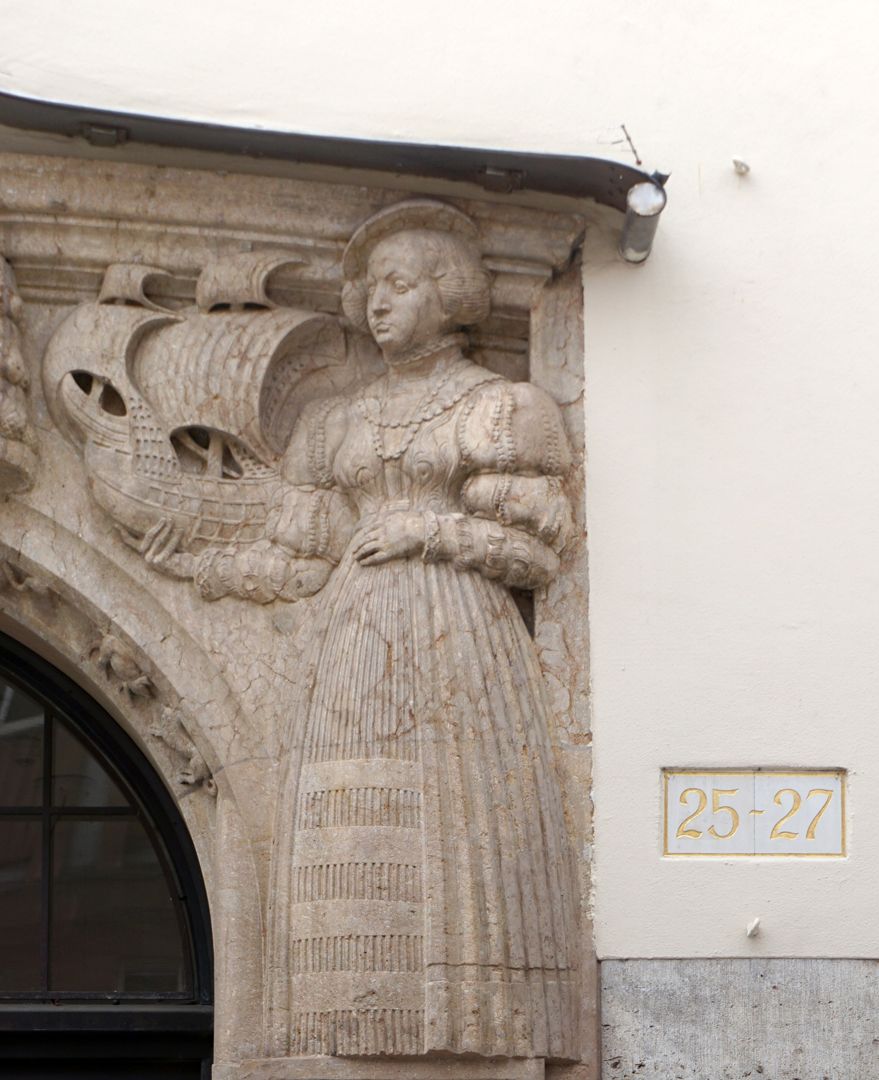 Portal rechte obere Ecke: eine Bürgerin in Renaissancekleidung hält ein Segelschiff