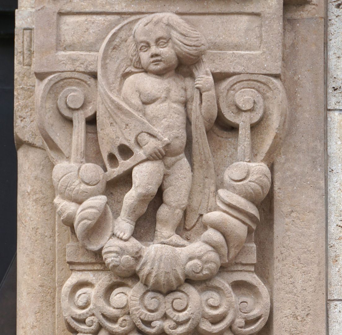Portal rechte Portallaibung, Detail mit Putto auf einem Muschelgehänge stehend und einem vom Wind aufgeblähtem Segeltuch über den Schultern