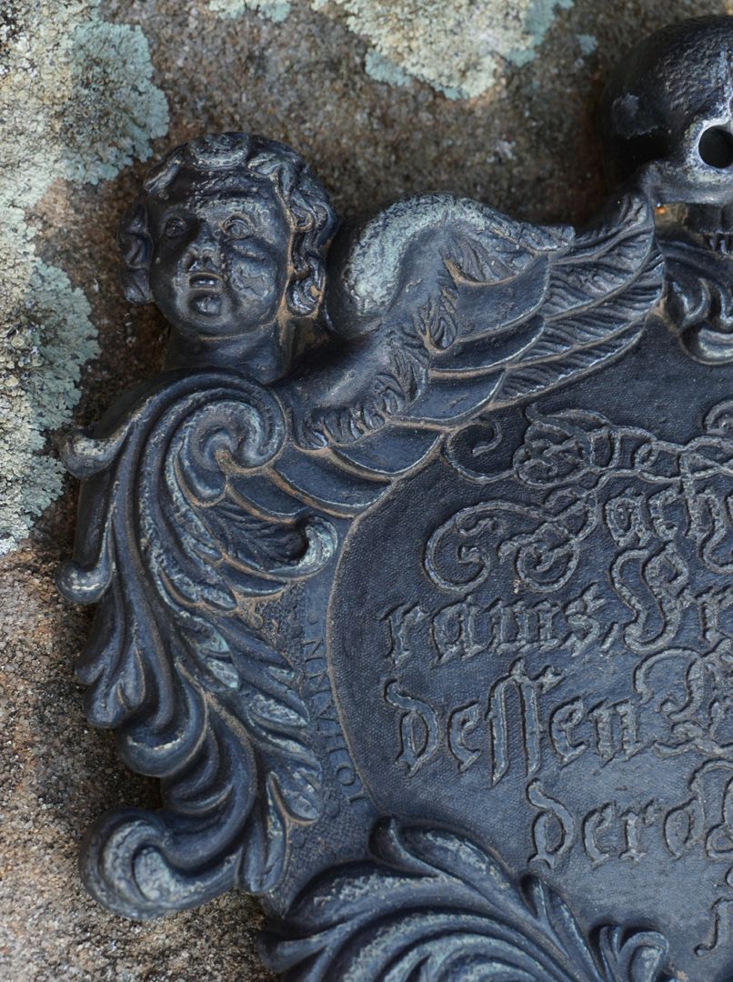 Epitaph des Zacharias Wolffram Detailansicht mit Cherub, daneben der Vorname des Künstlers
