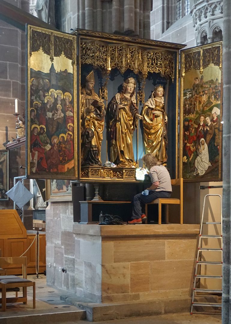 Katharinenretabel des Levinus Memminger Auf der Mensa sitzende Restauratorin verdeutlicht das Größenverhältnis zu den Figuren des Altares.