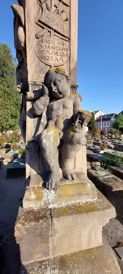 Gedächtnisstein des Wolfgang Müntzer Trauernder Putto an der Ostseite mit gesenkter Fackel und Stundenglas