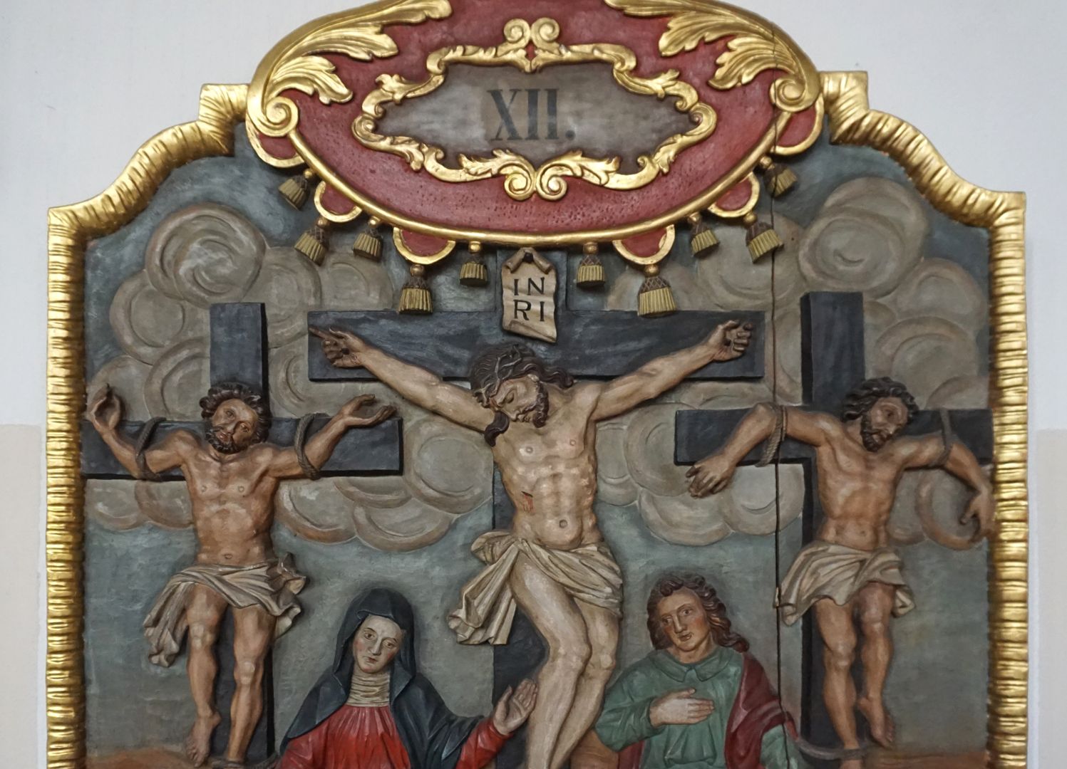Kreuzwegstation XII / Jesus stirbt am Kreuz obere Tafelhälfte mit Nummerierung, Jesus am Kreuz zwischen den zwei Schächern