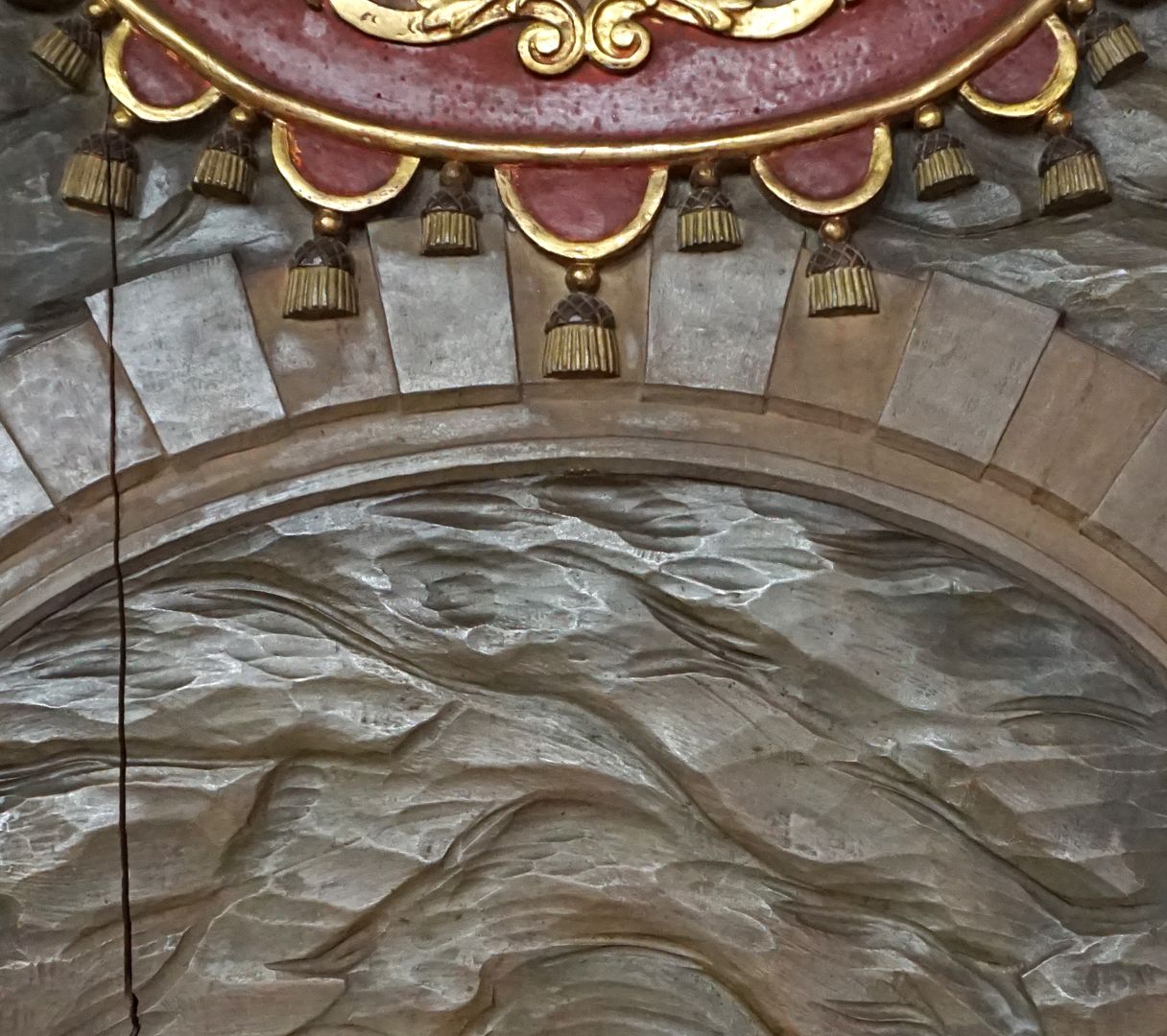 Kreuzwegstation XIV / Grabesruhe Detailansicht mit Troddeln an der oberen Kartusche und Rundbogen