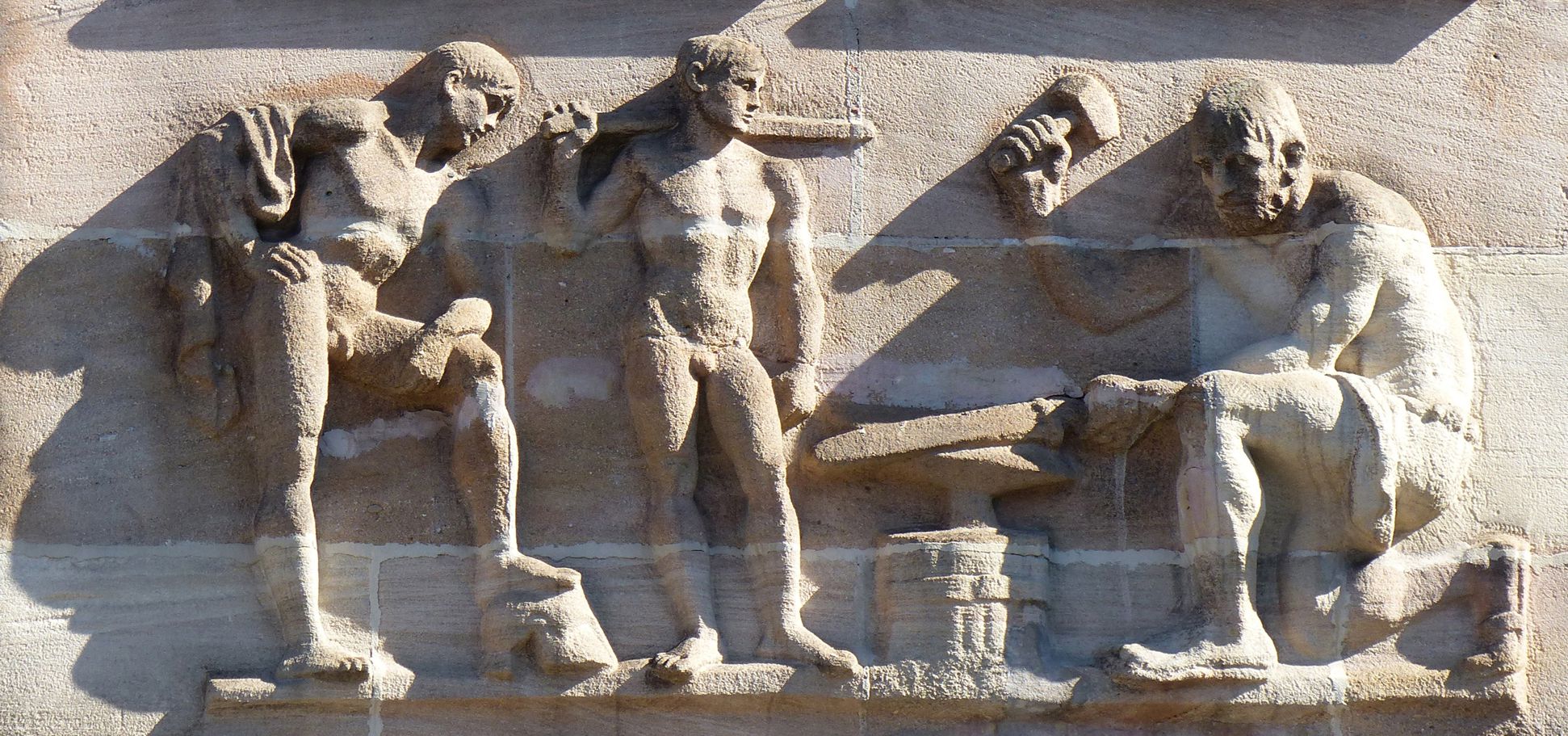 Sigmund Schuckert-Haus Chörlein, unteres Relief von Josef Wackerle im Streiflicht: Die Schmiede des Vulkans - Anspielung an Siemens