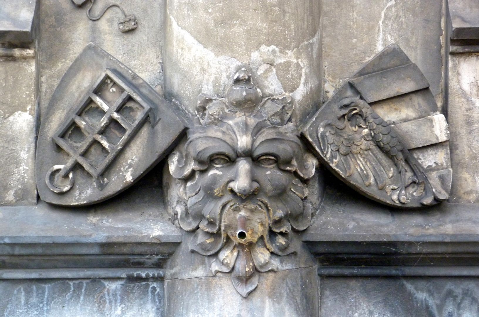 Teufleinsbrunnen Wasserspeier mit Blattmaske in der Mitte, links mit dem Wappen von St. Lorenz (Darstellung des Rostes auf dem er gemartert wurde) und rechts das Stadtwappen Nürnberg