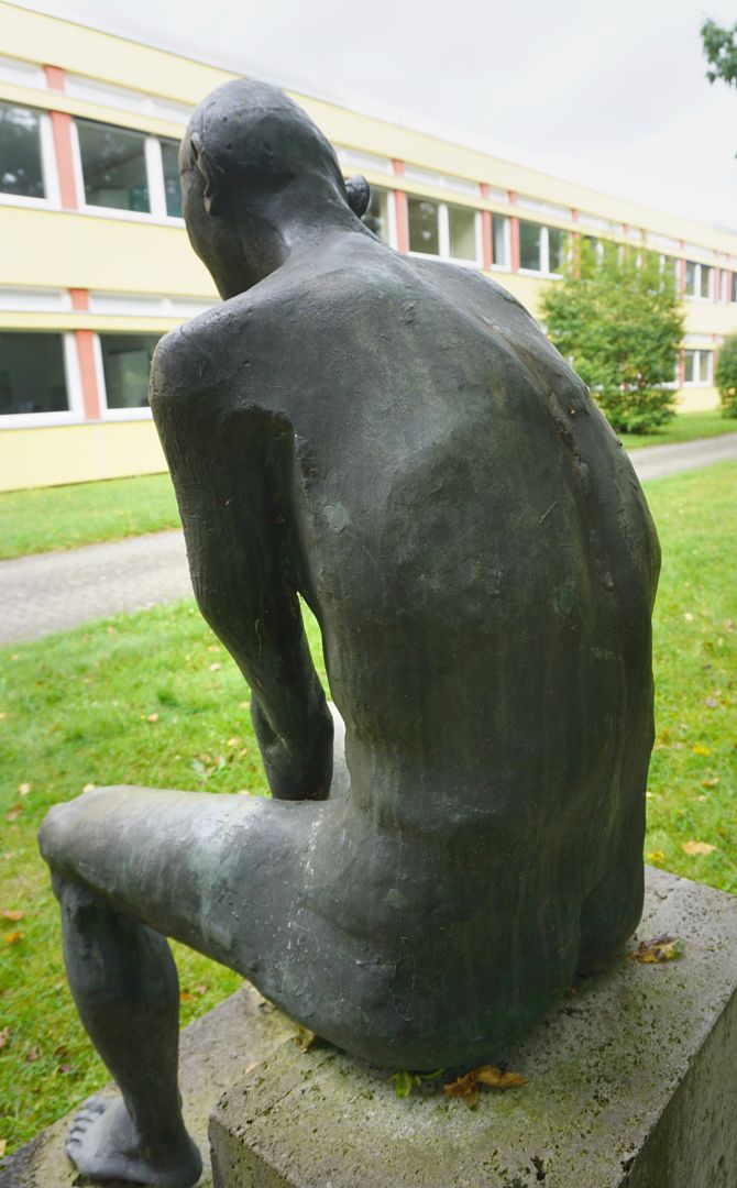 Sitzende Bronzefigur 